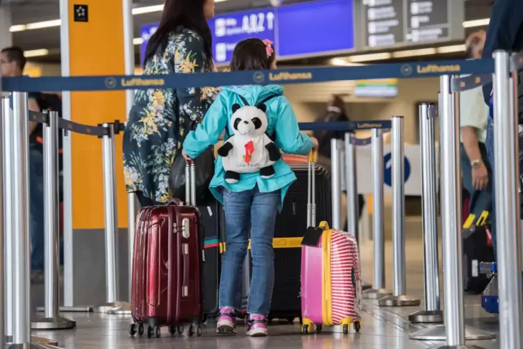 Ein Kind wartet am Check-in am Flughafen