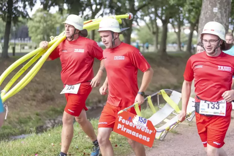  Pirmasenser Feuerwehrleute komplett mit Helm, Wasserschlauch und Trage beim Zweibrücker Firmenlauf 2023.