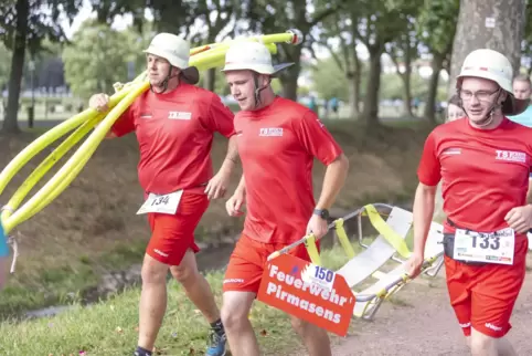  Pirmasenser Feuerwehrleute komplett mit Helm, Wasserschlauch und Trage beim Zweibrücker Firmenlauf 2023.