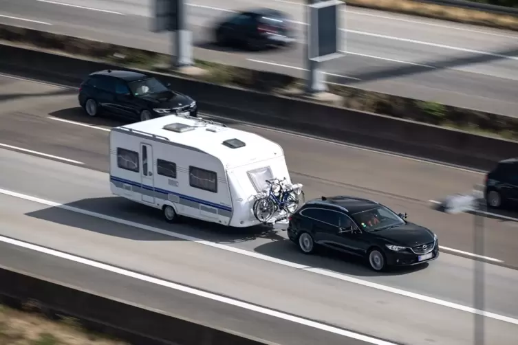 Ein Auto mit einem Wohnwagen fährt auf der Autobahn