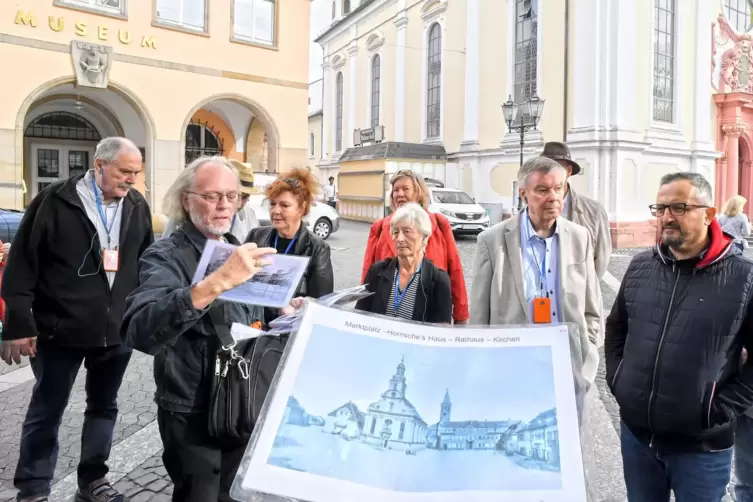Stadtführer Werner Schäfer (Zweiter von links) benutzt zur Veranschaulichung umfangreiches Bildmaterial.