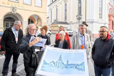 Stadtführer Werner Schäfer (Zweiter von links) benutzt zur Veranschaulichung umfangreiches Bildmaterial.