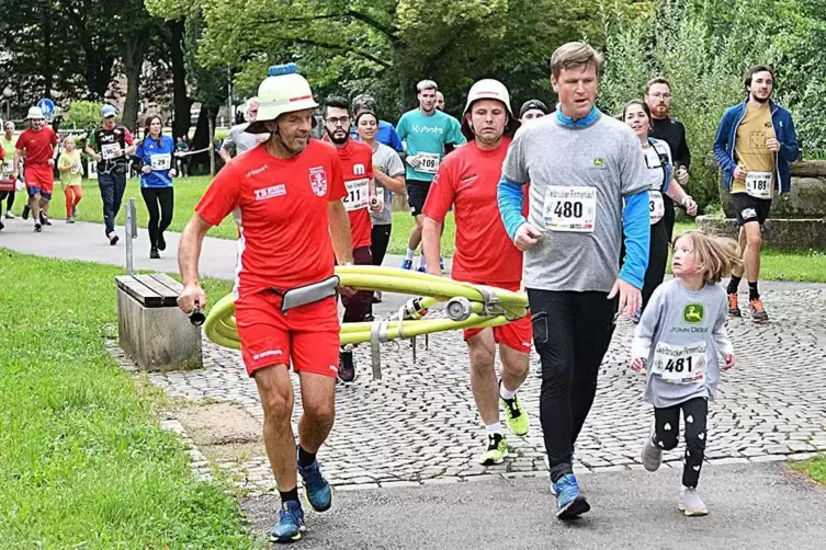 Die Pirmasenser Feuerwehrleute nutzten den Zweibrücker Firmenlauf quasi auch zu Trainingszwecken: Sie schleppten, gut behelmt, e