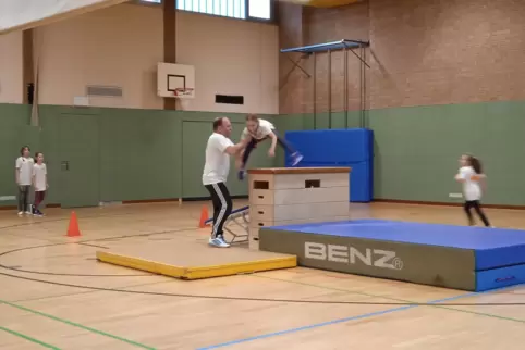 Sportlehrer Thomas Fritz hilft den Grundschülern beim Turnen. 