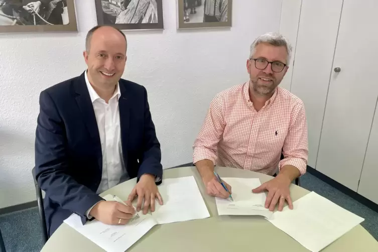 Markus Wolf (links) und Jochen Schmitt unterzeichnen die Koalitionsvereinbarung. 