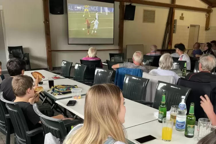 Mehrere Generationen schauen gemeinsam Fußball. 