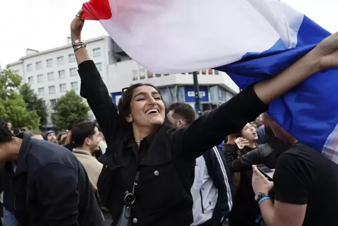 Eine Französin schwenkt die Nationalflagge und feiert so die ersten Hochrechnungen bei der zweiten Runde der Parlamentswahlen.