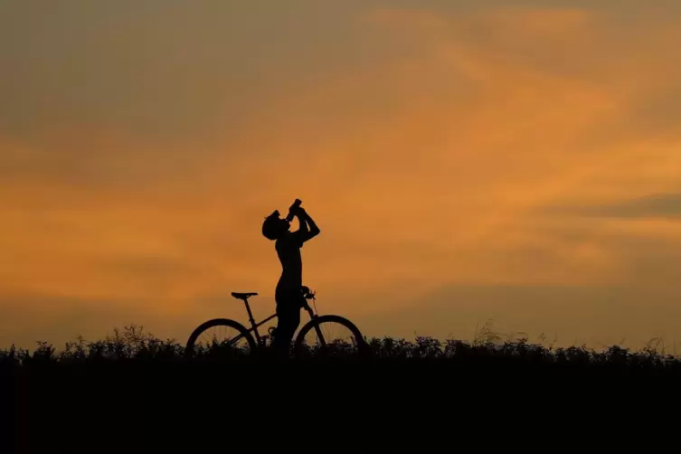 Ein Radfahrer macht eine kurze Trinkpause.