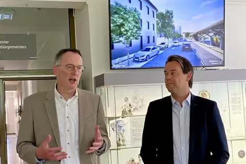 Innenminister Michael Ebling (links) und Oberbürgermeister Nicolas Meyer vor einer Visualisierung des neuen Bahnhofsumfeldes. 