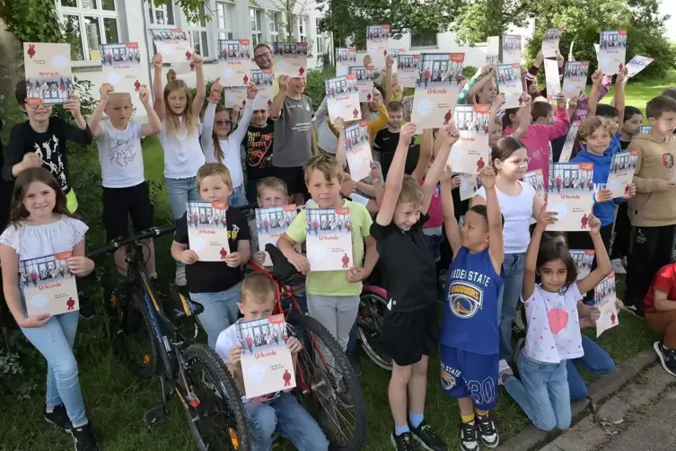 Kinder der Grundschule Husterhöhe freuen sich über Urkunden und den „SpoSpiTo“-Pass. 