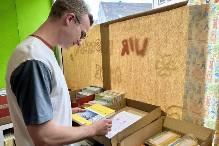 Beim Auspacken der Schulbücher muss „Praktikant Paul“ (alias RHEINPFALZ-Mitarbeiter Paul Helmut Kreiner) die Lieferscheine kontr