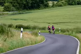 Zwei Radfahrer fahren auf einer Landstraße