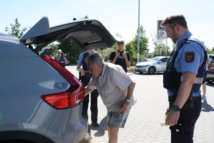 Polizeihauptkommissar Fabian Gwinner lässt sich vom 84-jährigen Erwin Rauer Warndreieck, Warnweste und Verbandskasten zeigen. De