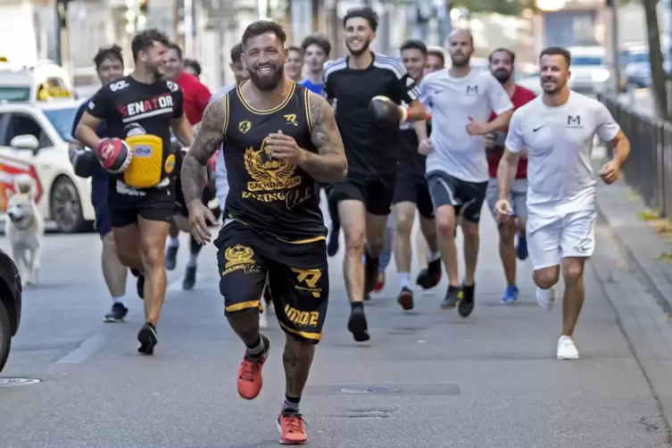 Eine Szene wie aus den Rocky-Filmen: Profiboxer Senad Gashi (vorne) und seine Boxschule joggen durch die Fruchtmarktstraße; Zwei