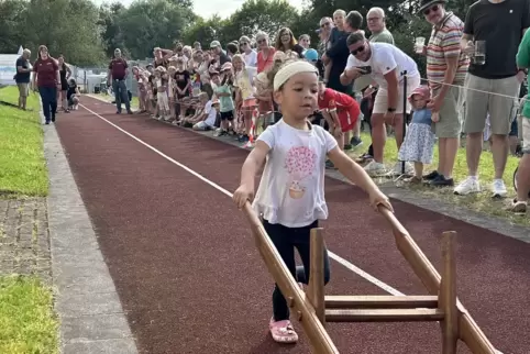 Fast im Ziel: Die vierjährige Zoe lenkt ihre Schubkarre über die Tartanbahn. Das Rennen bei der Kerwe ist gut besucht, an der St