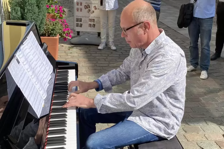 Oberbürgermeister Dominik Geißler an einem Klavier in der Fußgängerzone. 