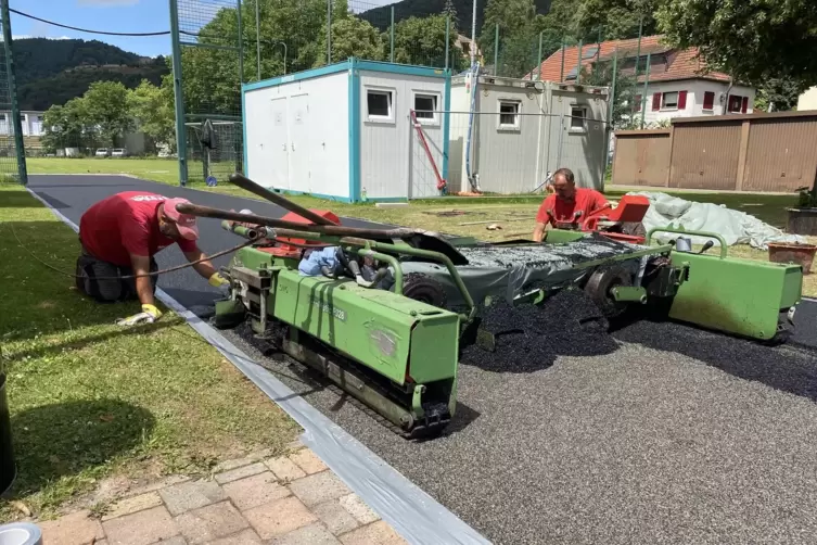 Spezialisten bringen die Gießbeschichtung am Anlauf für den Speerwurf auf. 