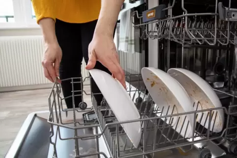Eine Frau räumt eine Spülmaschine ein