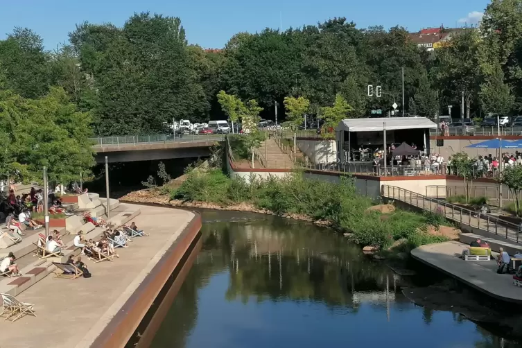 Blick auf die Neunkircher Bliesterrassen: Links von der Bühne sitzen die Leute auf den Treppen, vor der Bühne rechts stehen und 