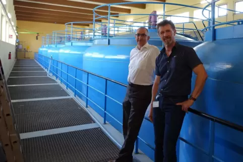  Thomas Mösl (links) und Rainer Barchet vor den großen blauen Filterbehältern der Bestandsanlage im Wasserwerk Maudach, in der 1