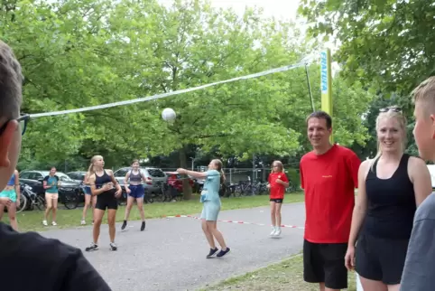 Freizeitleiter Eric Conrad (im roten Shirt) und Arabella Bernhard erklären die Regeln des Volleyballspielens.