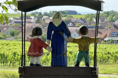Das Wollmesheimer Mütterle schaut mit den beiden Kindern aufs Dorf. 