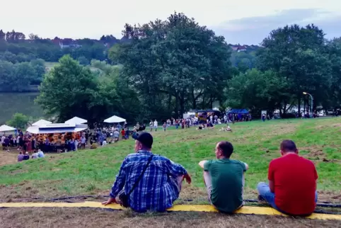 Eindrücke beim Seefest am Ohmbachsee in Schönenberg-Kübelberg: Drei Besucher sitzen fernab des Trubels und atmen durch. Im Hinte