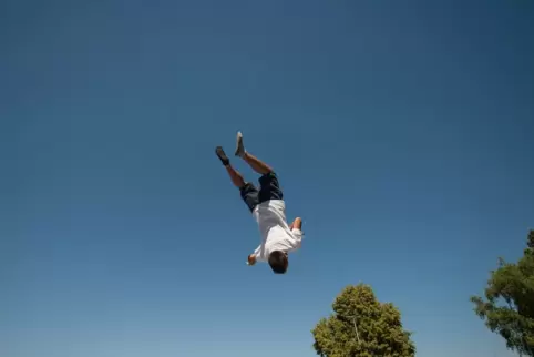 Ein Junge macht auf einem Trampolin einen Salto