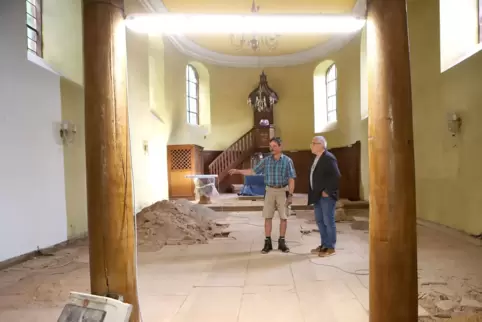 Matthias Thoni (links) und Rolf Kost in der ausgeräumten Kirche. Der Platz für Bänke und Altar muss neu organisiert werden.