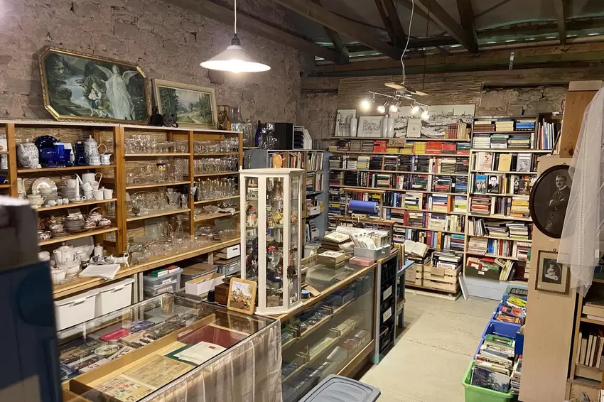 Blick vom Nähstübchen in den großen Flohmarkt-Raum mit Büchern und Geschirr.