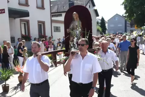 In einer feierlichen Prozession wird die Ortsheilige durch die Straßen getragen. 