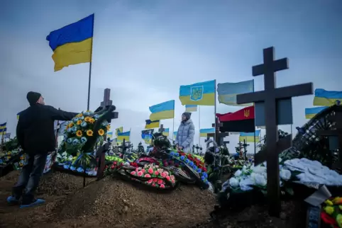Vater und Ehefrau eines gefallenen Soldaten auf einem Friedhof in der Ukraine.