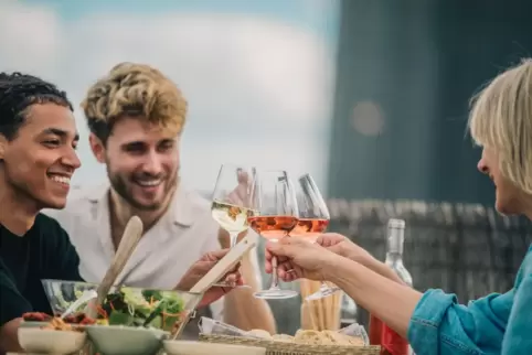 Freunde stoßen mit Wein an