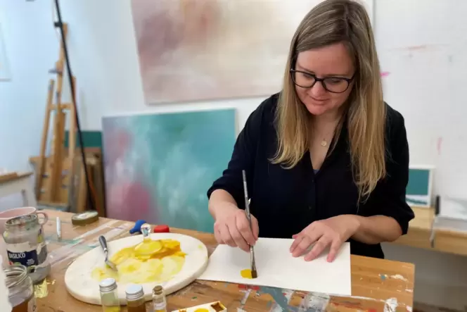 Kathleen Knauer zerreibt ein Pigment aus Färberkamille mit Wasser und Gummi arabicum unterm Glasläufer und testet den satten Gel