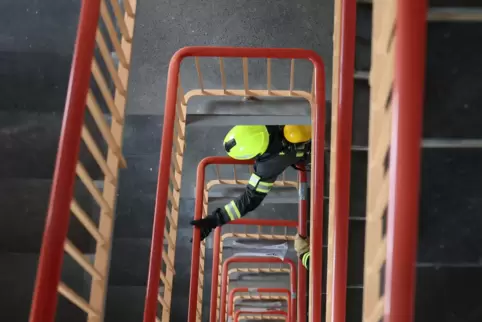 Ein Feuerwehrmann rennt eine Treppe hoch