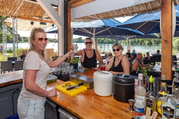 Cocktails bei Strandflair genießen (von links): Mitarbeiterin Mindy Willett , Marco Valerio und Anastasia Lösch, Geschäftsführer