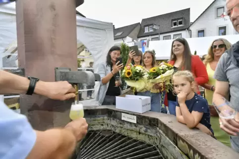 Endlich fließt Wein aus dem Dorfbrunnen (von links): Bürgermeisterin Natalie Bauernschmitt, Beigeordnete Angela Strobel, die Dür