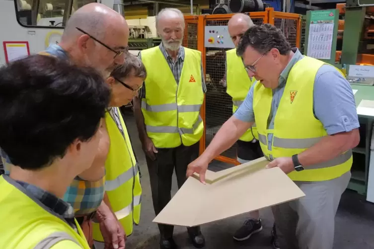 Prokurist Detlev Wessel (rechts), erläutert wie Wellpappe gemacht wird . 