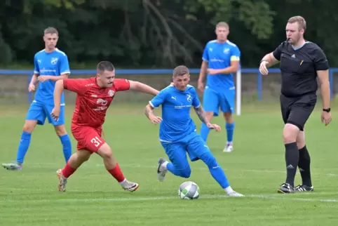 Der laufstarke Dirmsteins Marvin Ernst (rotes Trikot) verfolgt unter den Augen des guten Schiedsrichters Stefan Kopf den Altripe