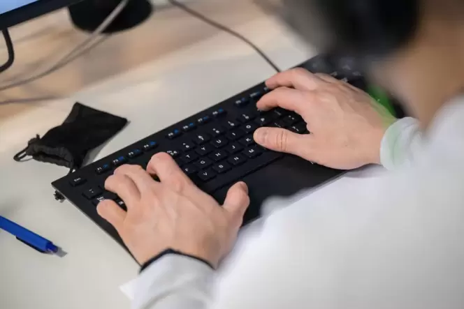Mann arbeitet an einer Computer-Tastatur