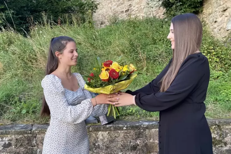 Die amtierende Kuseline Jil Biedinger (rechts im Bild) überreicht ihrer Nachfolgerin Mariana Varejão Pinheiro einen Blumenstrauß