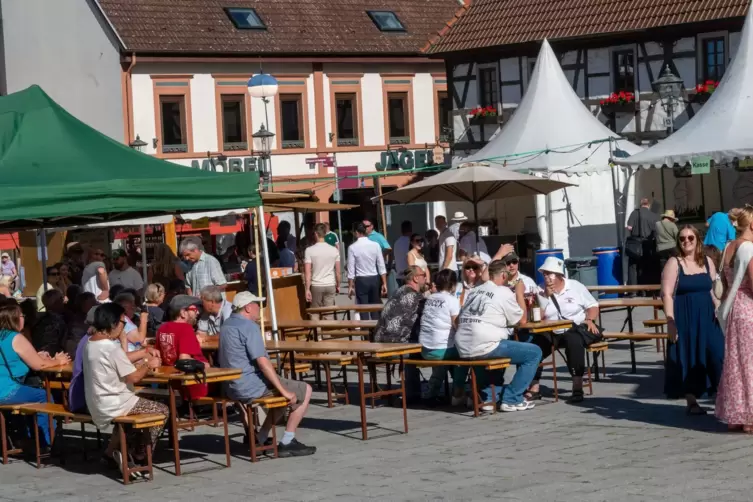 Besucher sichern sich kurz vor der Eröffnung auf dem Römerplatz ein Schattenplätzchen. 