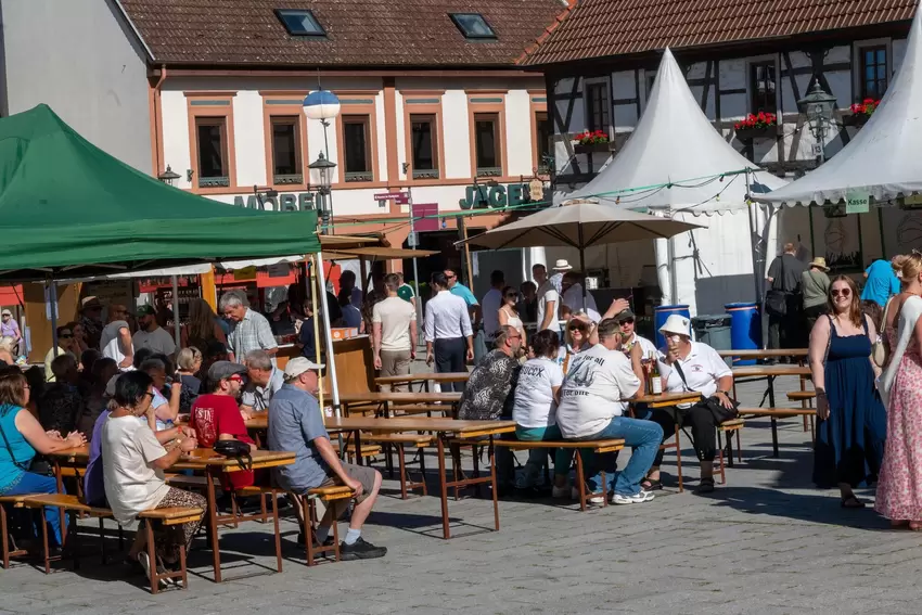 Besucher sichern sich kurz vor der Eröffnung auf dem Römerplatz ein Schattenplätzchen.