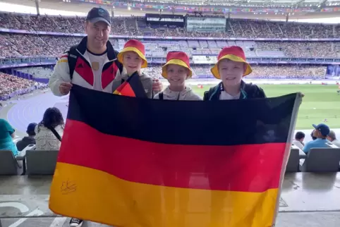 Michael Kraus mit seinen zwölfjährigen Drillingen (von links) Jesper, Silja und Joshua bei der Leichtathletik im Stade de France