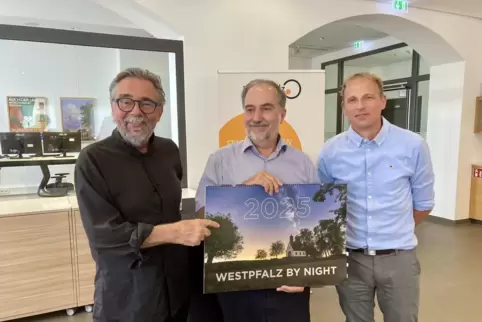 Fotograf Harald Kröher (links), Hans-Günther Clev (Zukunftsregion Westpfalz) und Druckereibesitzer Marcus Kalle präsentieren den