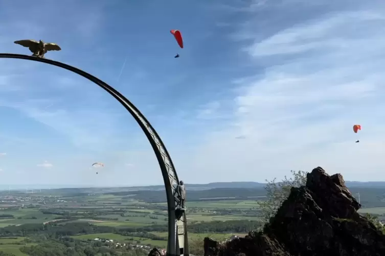 Drei Gleitschirmflieger kreisen um den Adlerbogen.