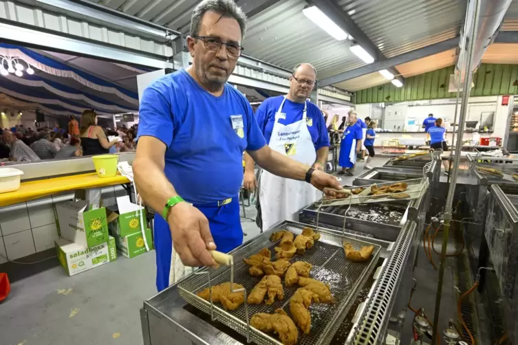 Fischerfest am Lambsheimer Weiher. An der Fischbraterei stehen (von links) Jacek Drozdz und Sven Püschel.