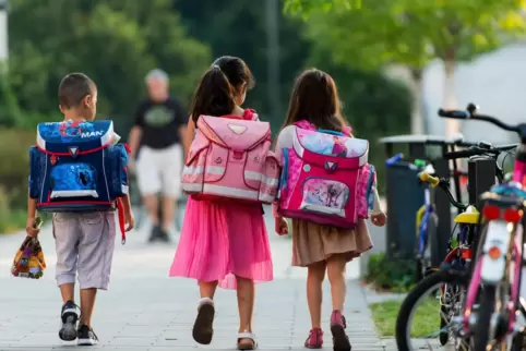 Kleine Kinder auf dem Schulweg (Archivbild). In Rheinland-Pfalz geht’s am Montag wieder los.