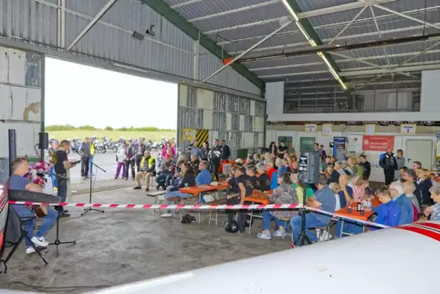 Wegen des Regens fand der Motorradgottesdienst im Hangar statt. Im Hintergrund sind auf dem Rollfeld aufgestellte Zweiräder zu s