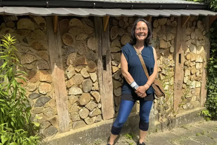 Petra Lohr vor der Bienenwand, die sie im Vorgarten ihres Hauses in Schiersfeld selbst gebaut hat.